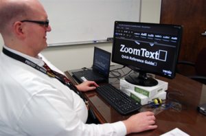 Photograph of a man using assistive technology on a PC